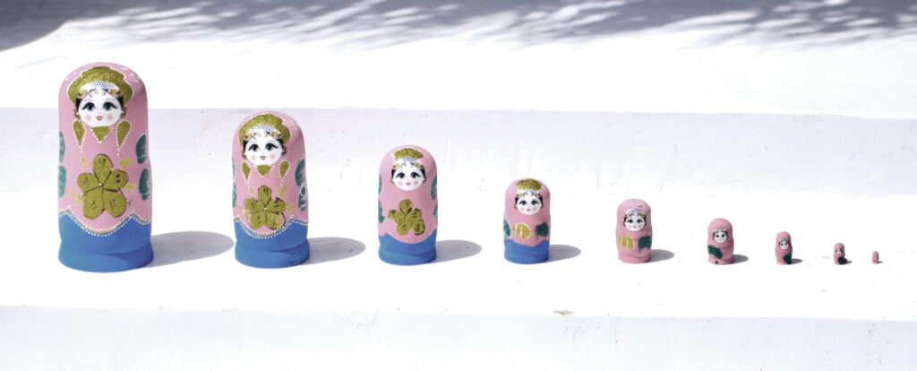 Matrjoschka mit 10 Puppen in rosa, blau und gold, steht für verschiedene Entwicklungsstufen und innere, unbewusste Anteile, Bewusstwerdung, Veränderungsprozes, Selbstannahme, Selbsterkenntnis, inneres Wachstum, Perspektivwechsel, Heilung, innere Kind Arbeit