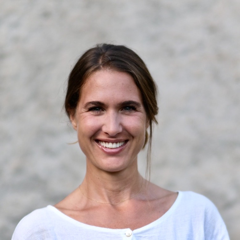 Portrait von Pascale Clement,Ärztin, Coach und Organisationsnetwicklerin, freundlich, offener Blick, mittleren Alters, braune, zusammengebundene Haare